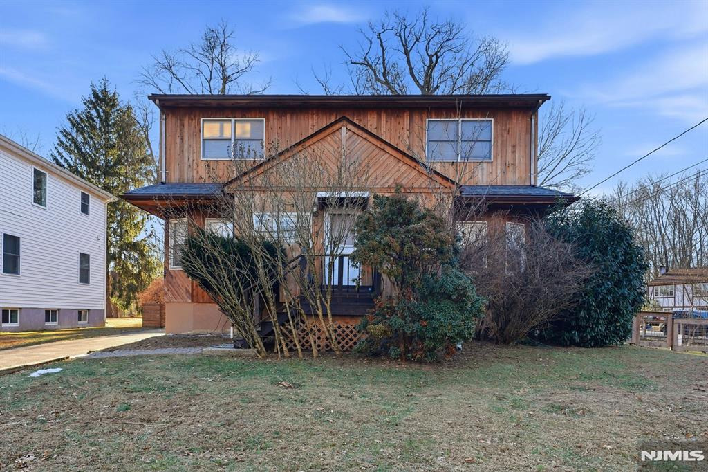 Before and after real estate photo enhancement of a cedar-sided colonial home exterior — before